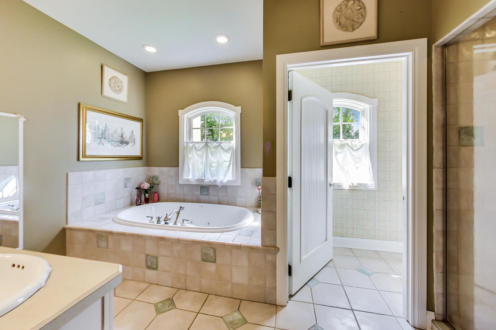 8901 Maple Avenue Burr Ridge, IL 60527 - Photo 25 of 68 a bathroom with a tub a sink and a mirror