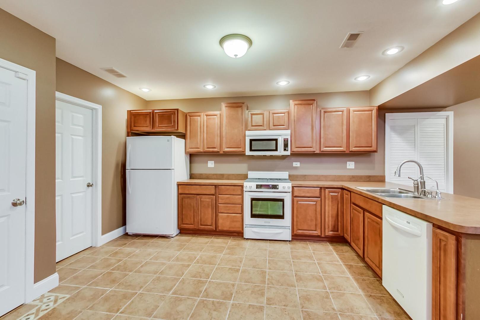 8901 Maple Avenue Burr Ridge, IL 60527 - Photo 39 of 68 a kitchen with stainless steel appliances granite countertop a refrigerator sink stove microwave and cabinets