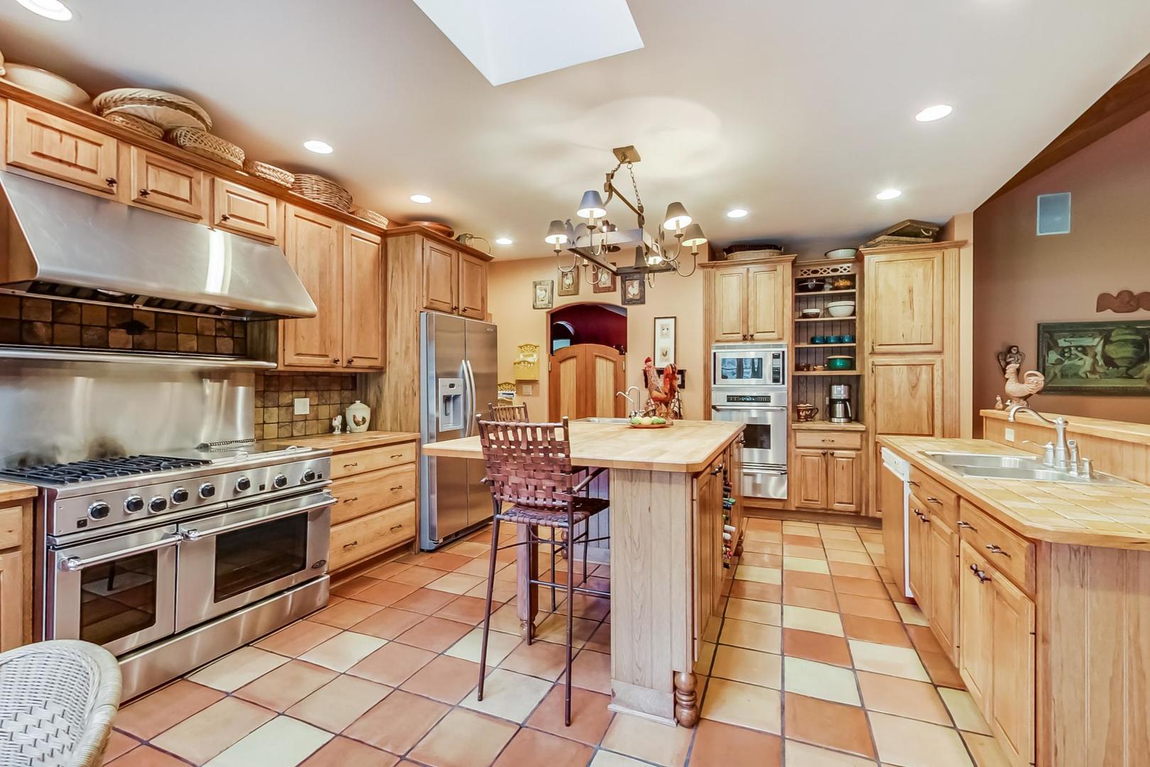 8901 Maple Avenue Burr Ridge, IL 60527 - Photo 10 of 68 a kitchen with stainless steel appliances granite countertop a sink a stove a chimney a dining table and chairs