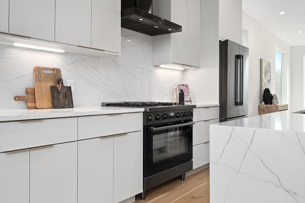 1104 Gunter Street, Unit 1/2 Austin, TX 78702 - Photo 19 of 40 a kitchen with stainless steel appliances granite countertop a sink and a stove