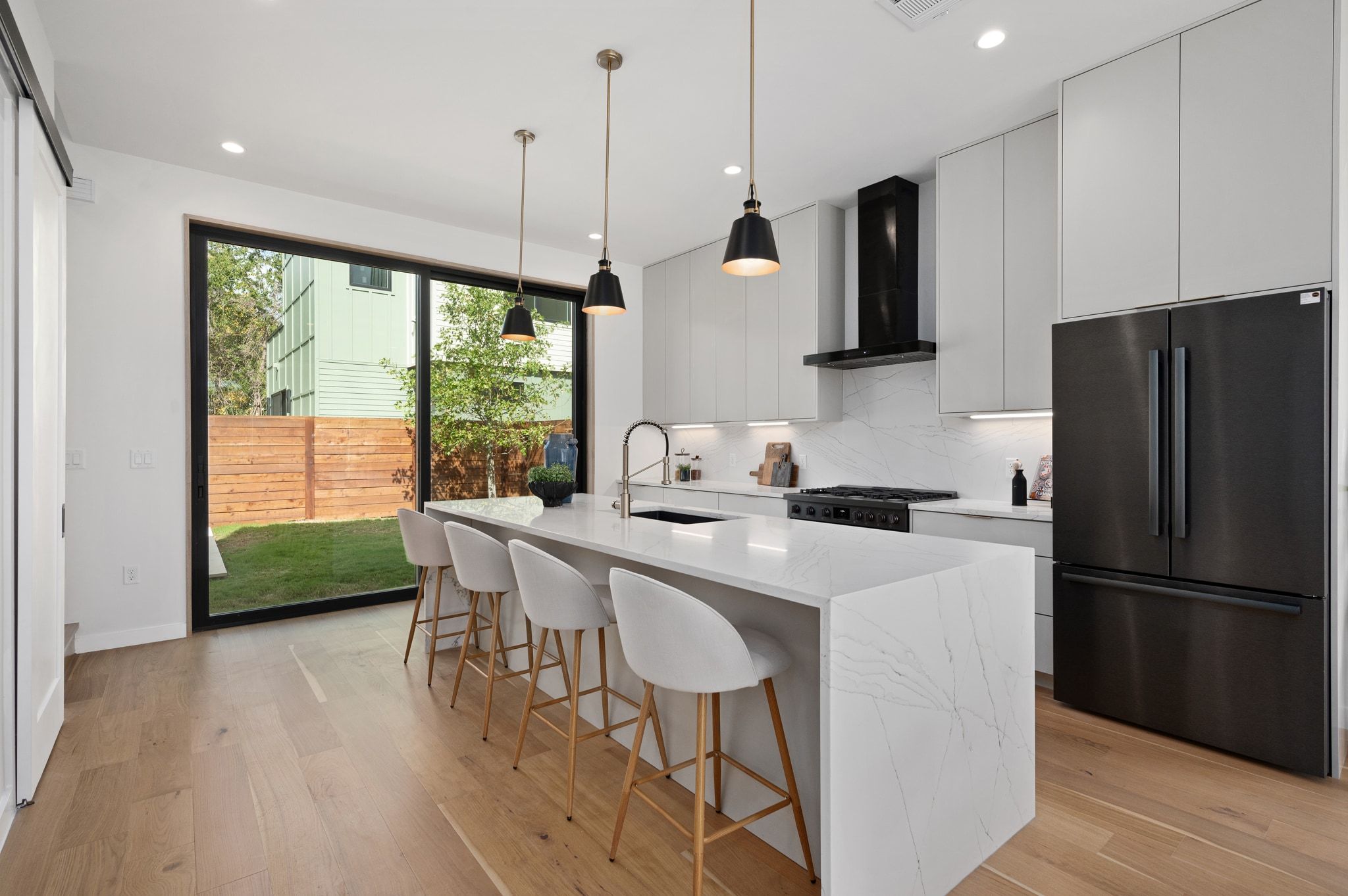 1104 1/2 Gunter Street Austin, TX 78702 - Photo 4 of 40 a kitchen with stainless steel appliances granite countertop a stove a refrigerator a sink a microwave oven with a dining table and chairs