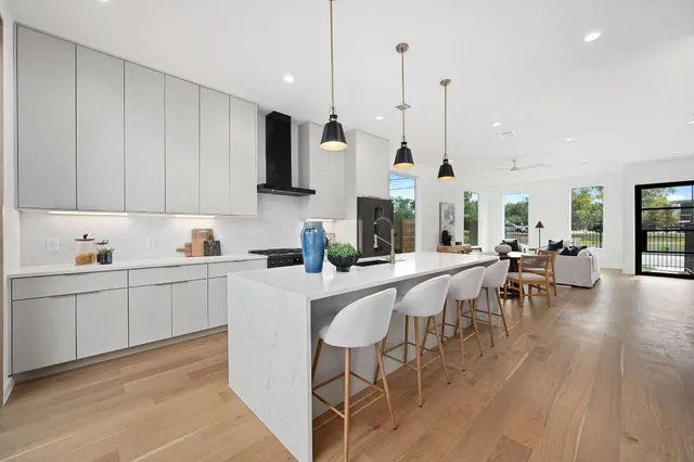 a kitchen with appliances a sink a counter top space and a center island