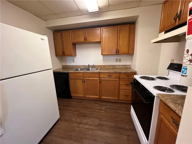 a kitchen with a sink a stove a refrigerator a washer dryer and cabinets