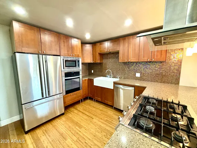 a kitchen with stainless steel appliances granite countertop a refrigerator and a sink