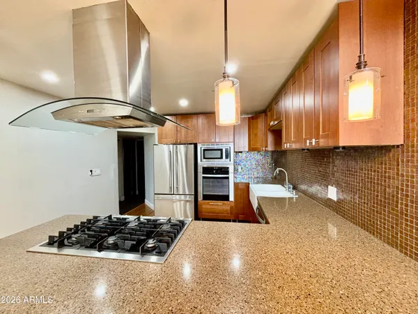 a kitchen with stainless steel appliances granite countertop a sink stove and refrigerator