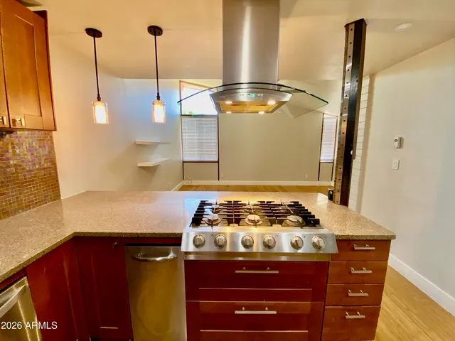 a kitchen with a stove and a wooden floor