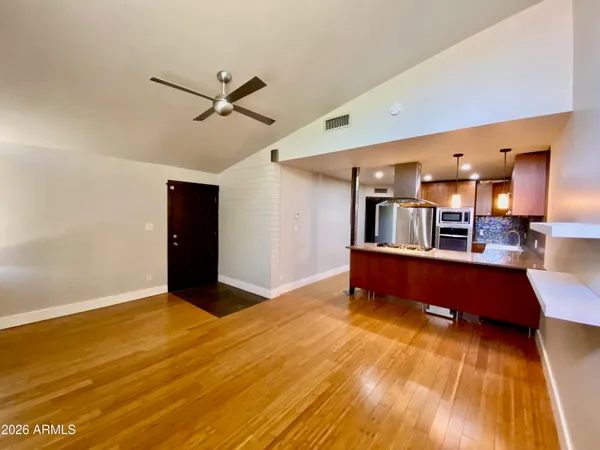a view of a room with wooden floor and a ceiling fan