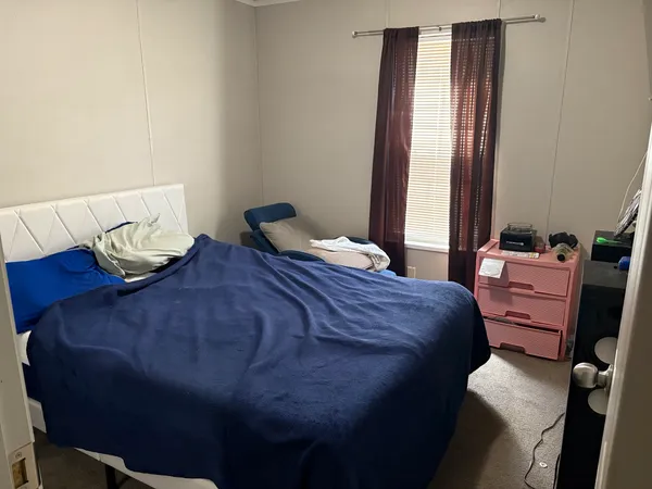 a view of a bedroom with wooden floor and furniture