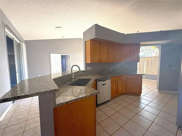 a kitchen with granite countertop a sink and a stove