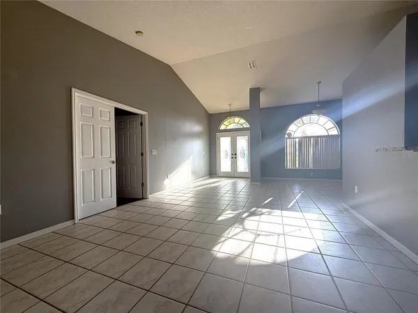 a view of a hallway with windows and chandelier