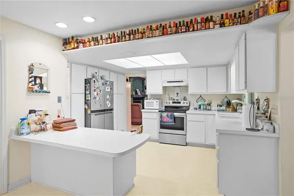 a kitchen that has a lot of cabinets a sink and a refrigerator