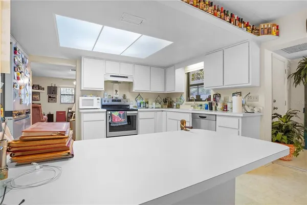 a kitchen with stainless steel appliances kitchen island granite countertop a refrigerator and a sink