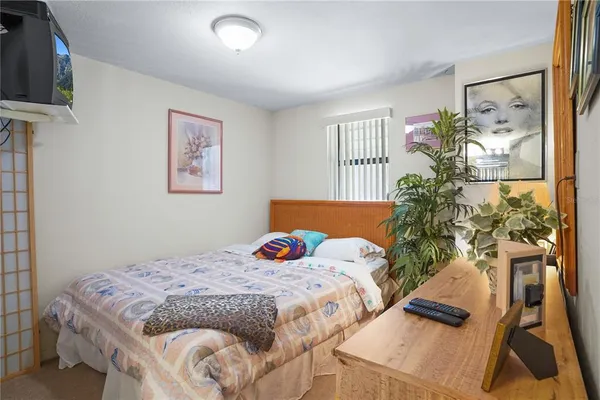 a bedroom with a bed and a painting on the wall