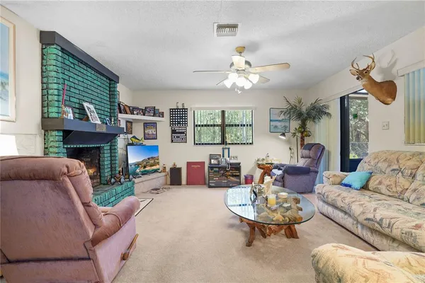 a living room with furniture a fireplace and a large window