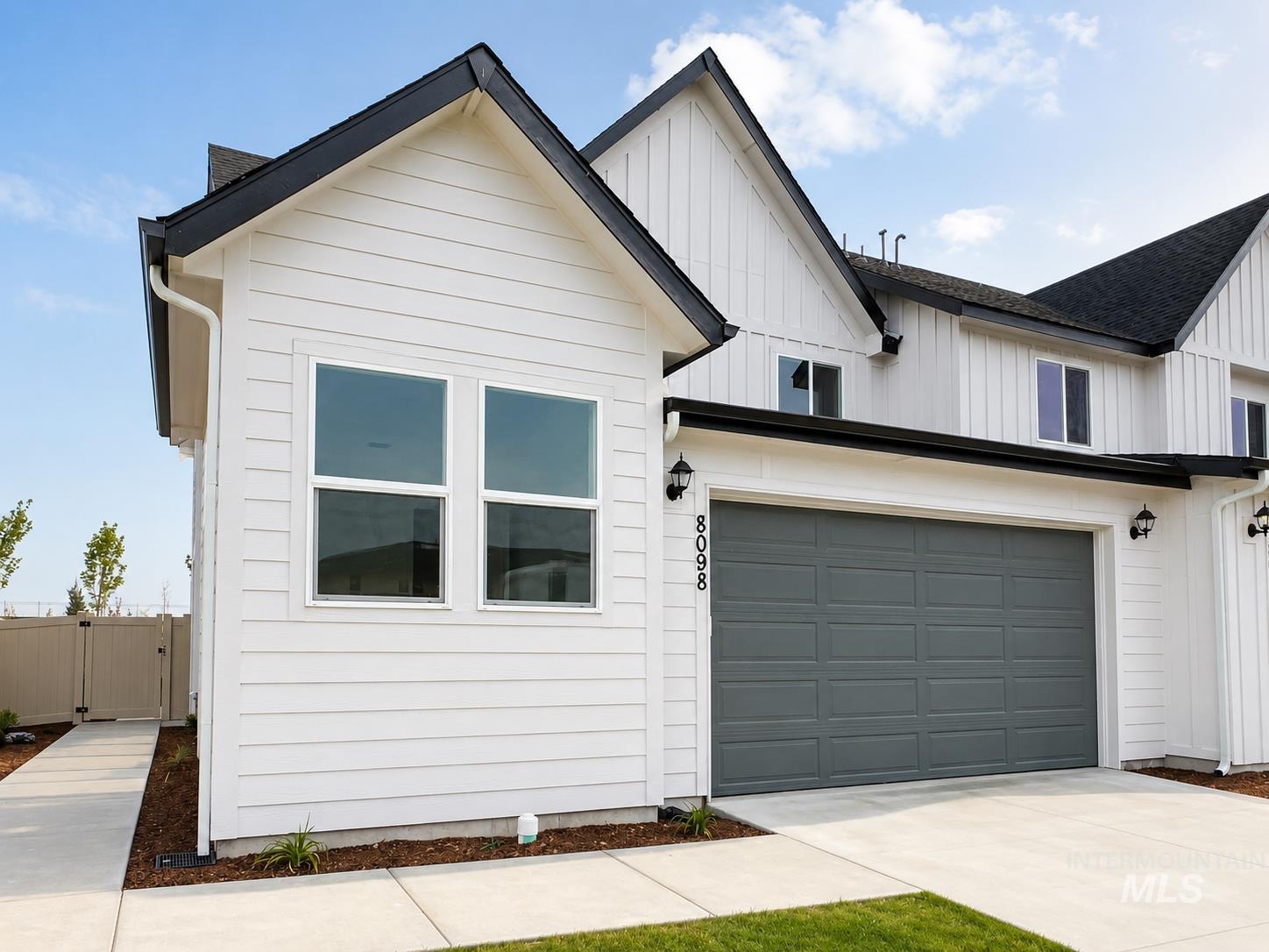 8098 West Fern Street Eagle, ID 83616 - Photo 1 of 22 Modern farmhouse exterior featuring white horizontal siding, black trim accents, a dark gray garage door, and a concrete driveway