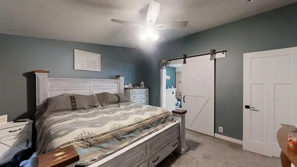 a bedroom with a bed and a refrigerator