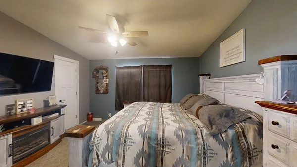 a bedroom with a bed and a flat screen tv