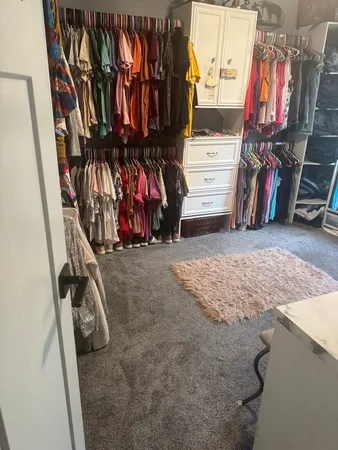 a view of walk in closet with clothes