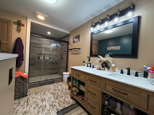 a en suite bathroom with a double vanity sink and a mirror