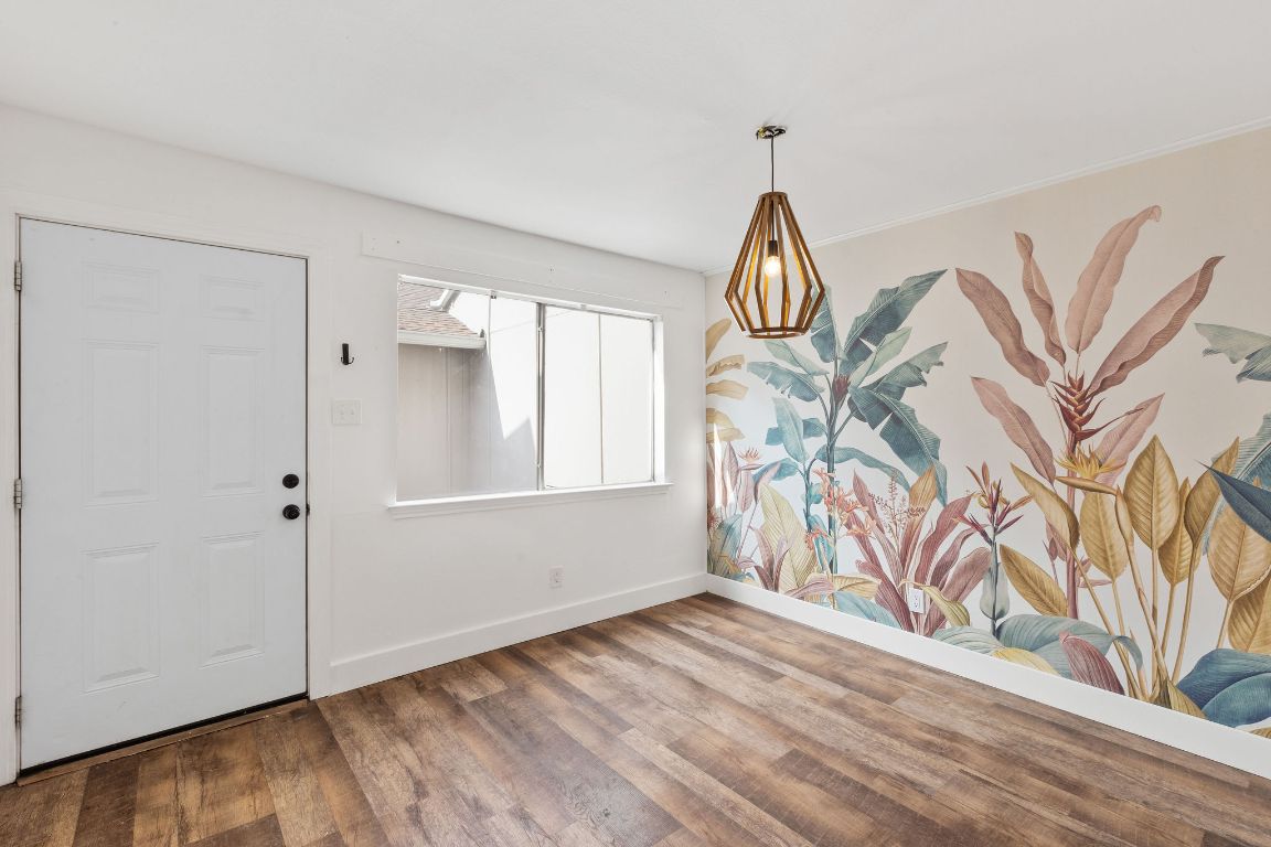1712 Timber Ridge Road Austin, TX 78741 - Photo 11 of 35 Unfurnished dining area with baseboards and wood finished floors