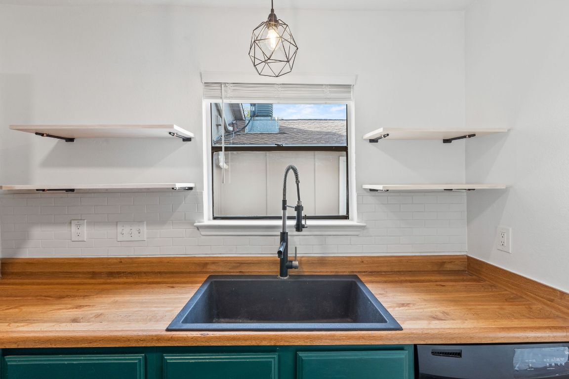 1712 Timber Ridge Road Austin, TX 78741 - Photo 14 of 35 Kitchen featuring open shelves, green cabinetry, wood counters, and dishwasher