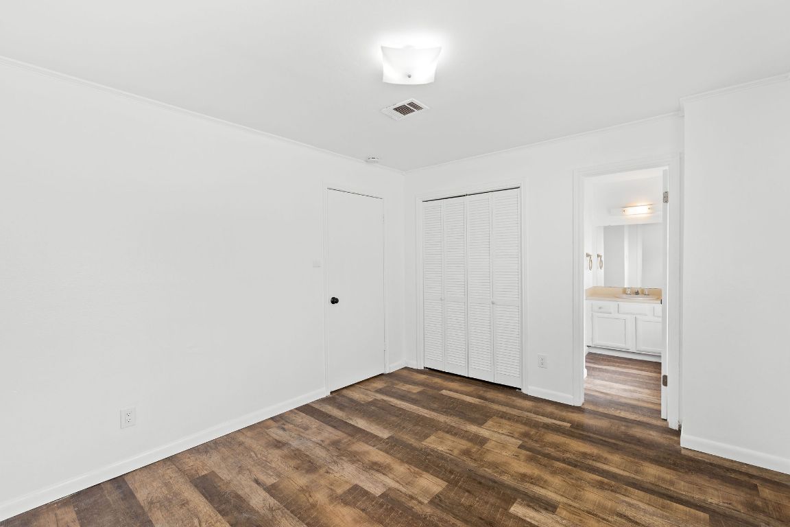 1712 Timber Ridge Road Austin, TX 78741 - Photo 21 of 35 Unfurnished bedroom with dark wood finished floors and a closet