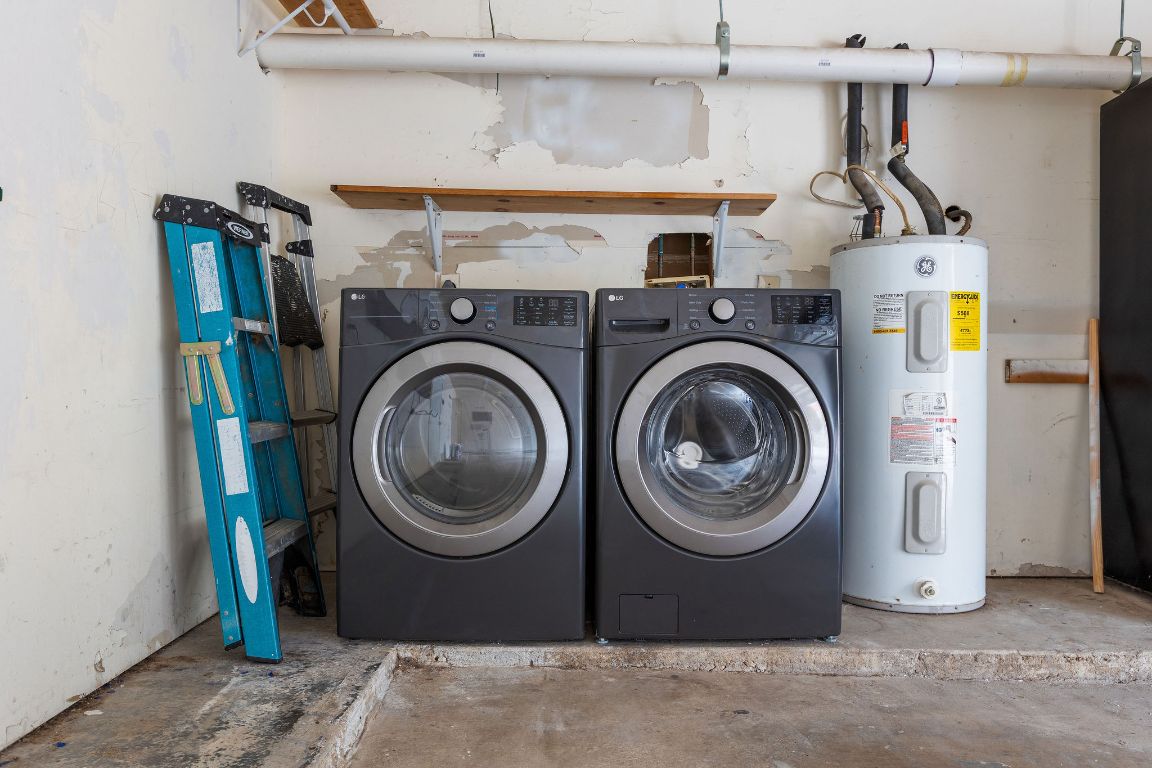 1712 Timber Ridge Road Austin, TX 78741 - Photo 33 of 35 Washroom featuring concrete floors, electric water heater, and separate washer and dryer