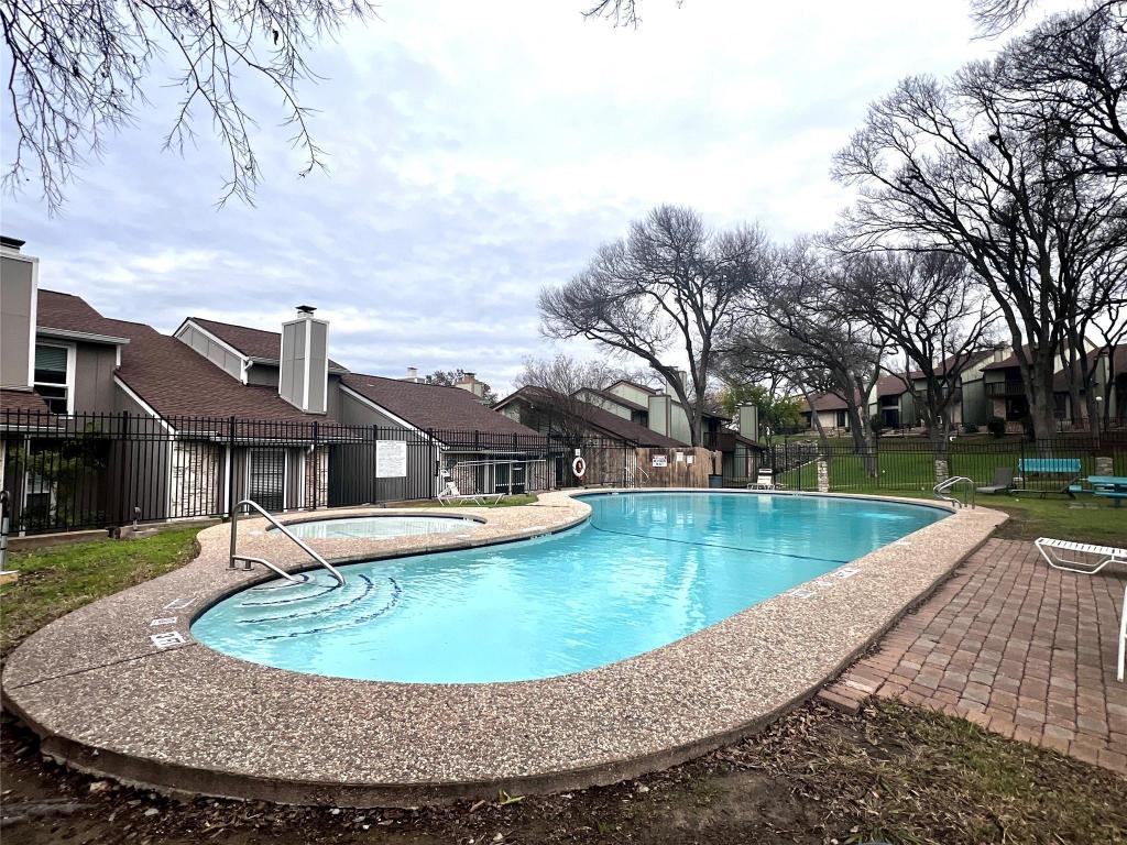 1712 Timber Ridge Road Austin, TX 78741 - Photo 35 of 35 Community pool featuring a residential view, a patio area, and a hot tub