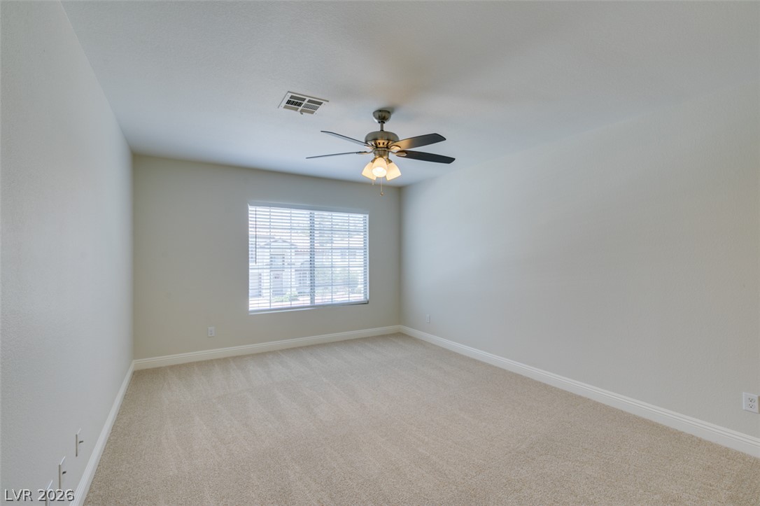 200 Luninborg Street Henderson, NV 89074 - Photo 29 of 40 A well-lit bedroom features plush carpeting and a modern ceiling fan, ready for personal touches.