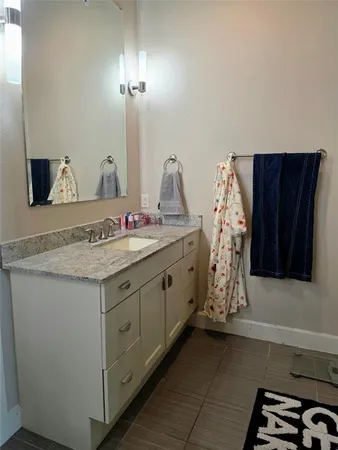 a bathroom with a granite countertop sink and a mirror