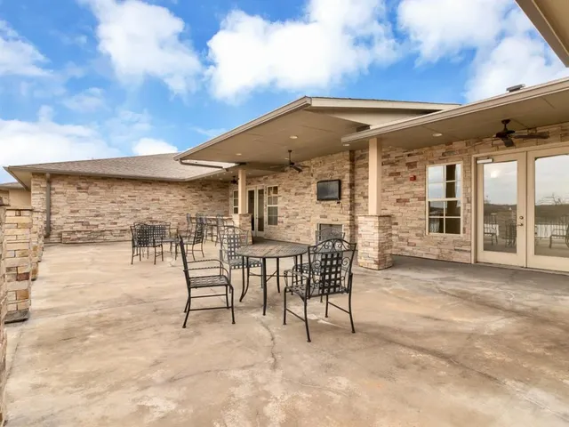 a view of a patio with table and chairs with wooden floor and fence