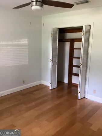 an empty room with a hardwood and closet