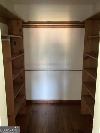 a view of a walk in closet with wooden floor
