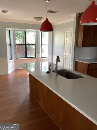 a large kitchen with stainless steel appliances a large counter top a stove and a window