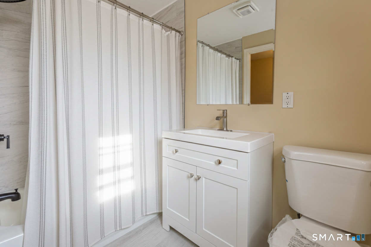 5 Lawler Road West Hartford, CT 06117 - Photo 21 of 33 a bathroom with a toilet a sink and a window