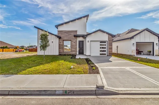 a view of a house with a yard and a garage