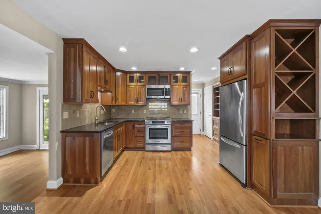 a kitchen with stainless steel appliances granite countertop a refrigerator and a stove top oven