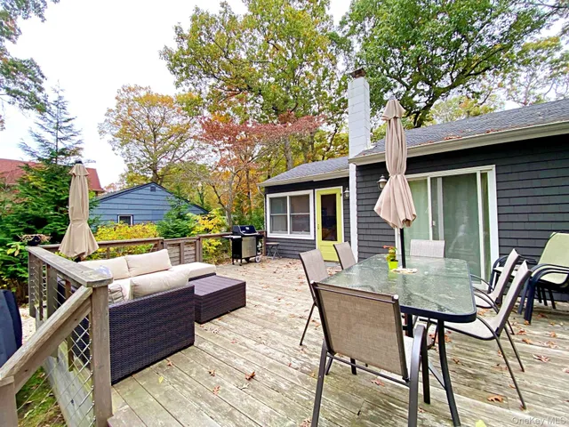 a view of a patio with table and chairs and wooden fence