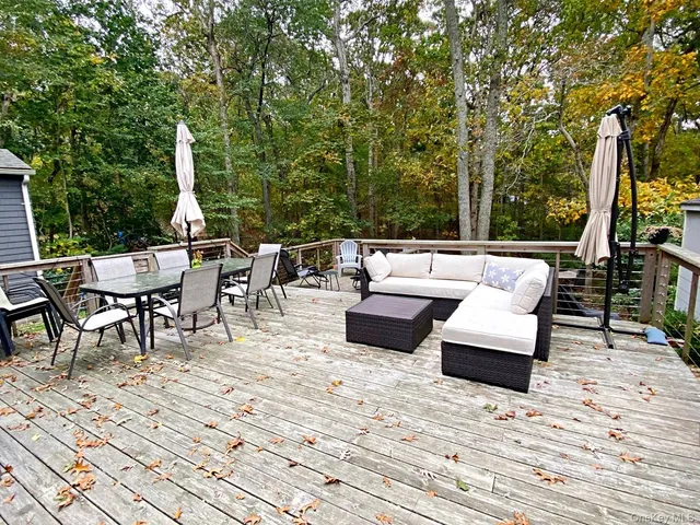 a view of a patio with dining table and chairs with wooden floor and fence