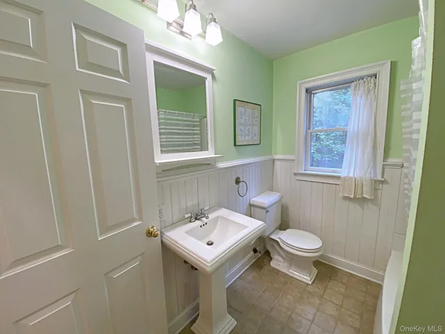 a bathroom with a sink toilet and window