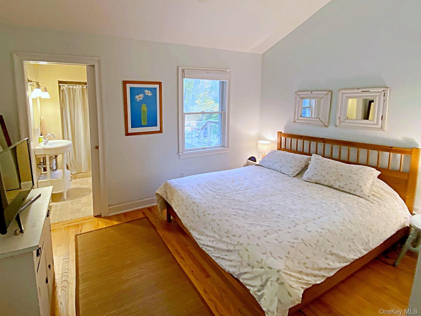 1855 Kenneys Road Southold, NY 11971 - Photo 9 of 18 a bedroom with a bed and wooden floor