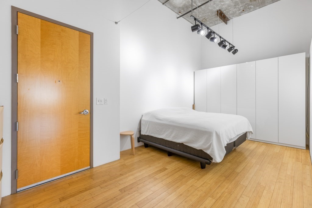 156 Porter Street, Unit 249 Boston, MA 02128 - Photo 11 of 30 a bedroom with a bed and wooden floor