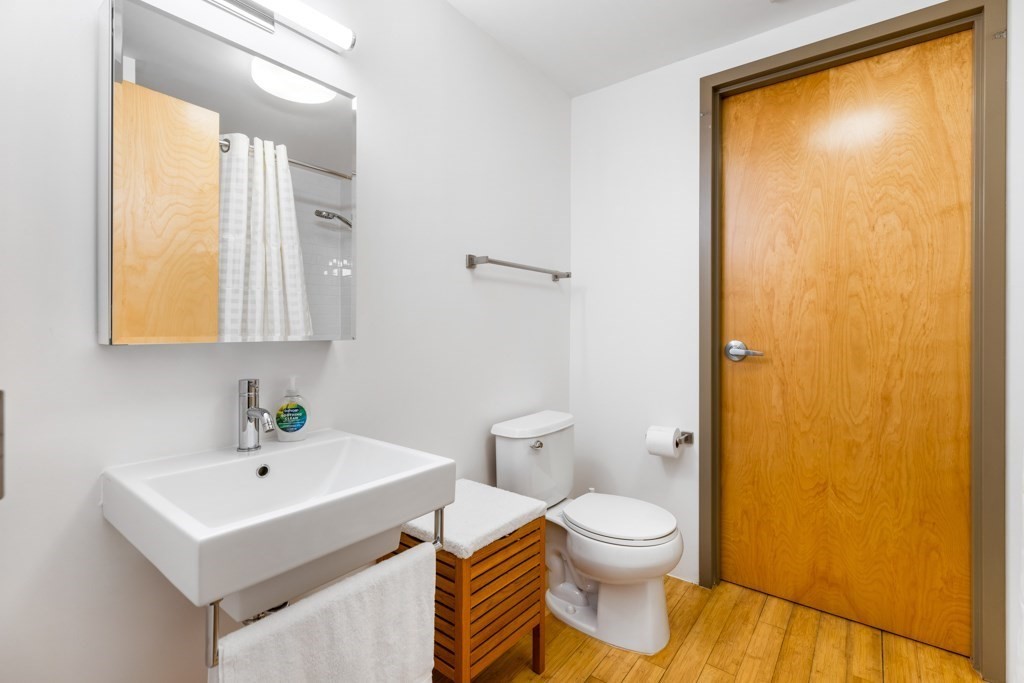 156 Porter Street, Unit 249 Boston, MA 02128 - Photo 13 of 30 a bathroom with a toilet a sink and a mirror