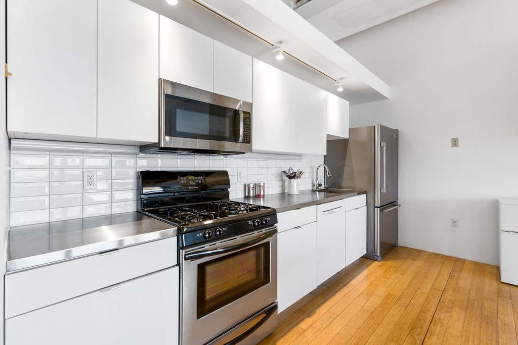 156 Porter Street, Unit 249 Boston, MA 02128 - Photo 2 of 30 a kitchen with stainless steel appliances a stove microwave and a refrigerator