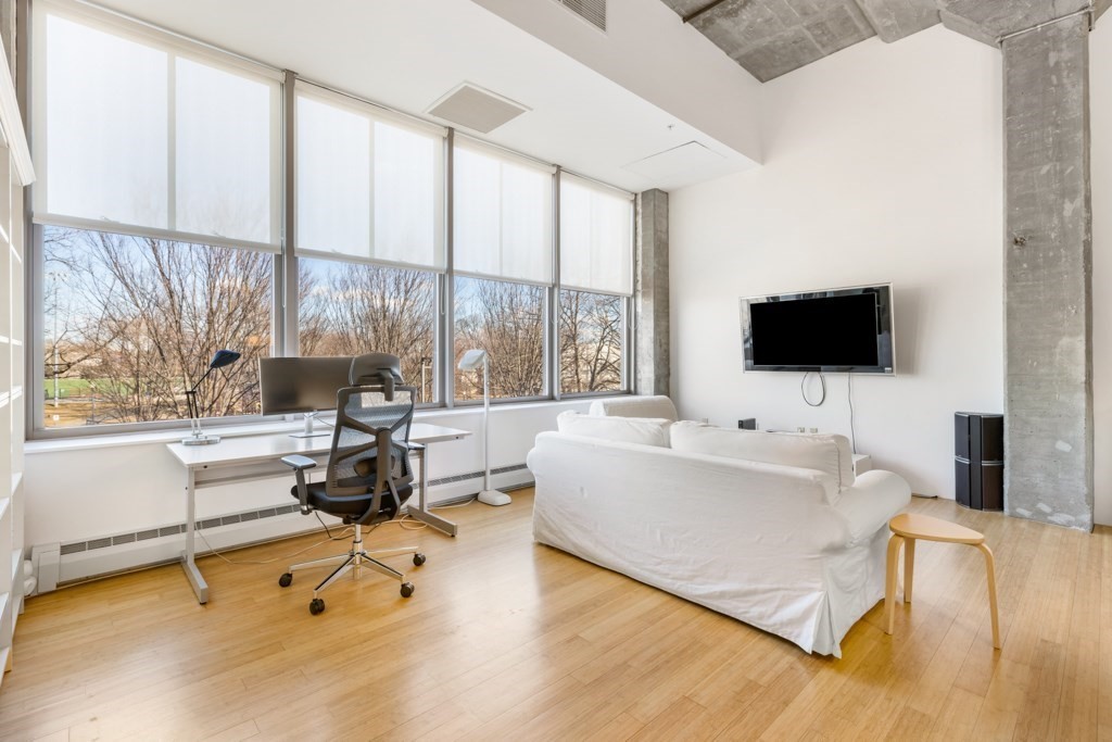 156 Porter Street, Unit 249 Boston, MA 02128 - Photo 8 of 30 a living room with a flat screen tv and a floor to ceiling window