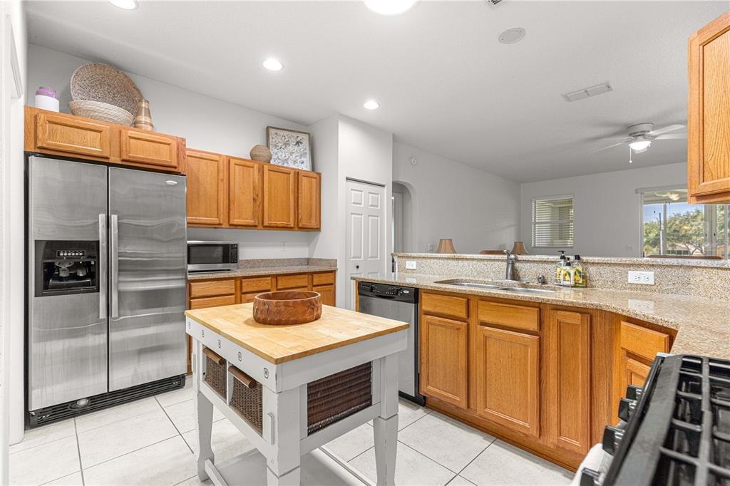 9317 Southwest 94th Loop Ocala, FL 34481 - Photo 12 of 40 a kitchen with a stove sink and refrigerator