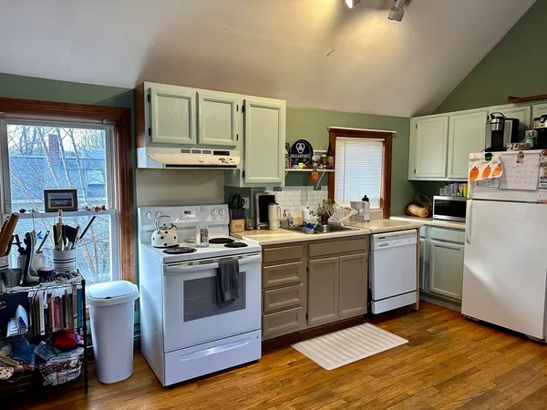 a kitchen with a sink stove and white cabinets