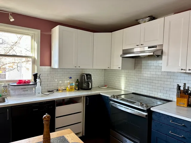 a kitchen with kitchen island granite countertop a sink a stove and cabinets