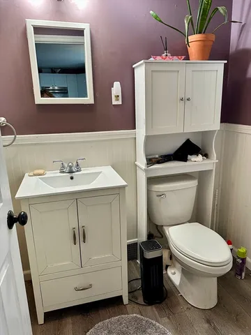 a bathroom with a toilet sink and mirror