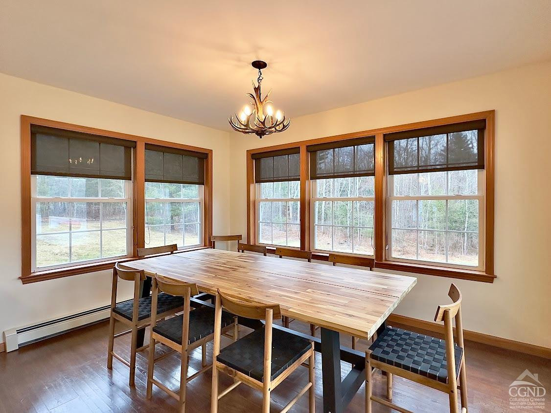 90 Cramer Road Jewett, NY 12444 - Photo 15 of 50 a dining room with wooden floor a chandelier a wooden table and chairs